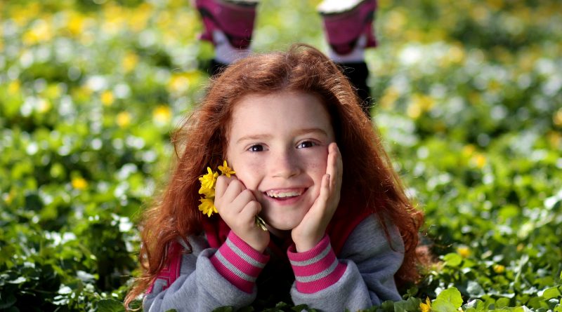 Kind auf Wiese mit Blume