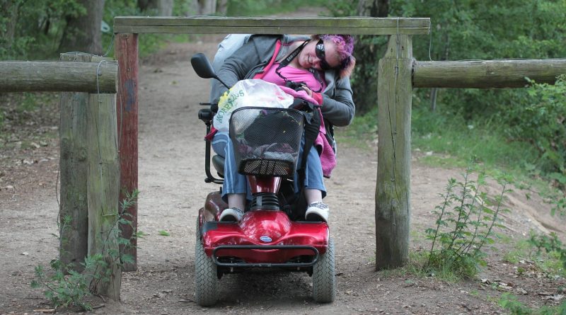 Frau im Rollstuhl an einer Barriere