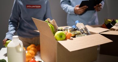 Freiwillige Helfer packen eine Kiste mit Lebensmitteln