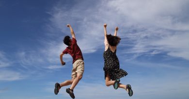 eine Frau und ein Mann springen vor Freude in die Luft